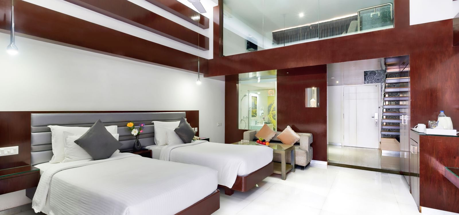 A clean hotel room featuring two beds with white linens, wooden accent walls, and a large window | Grande Duplex Twin | Grand Bay Resort and Spa