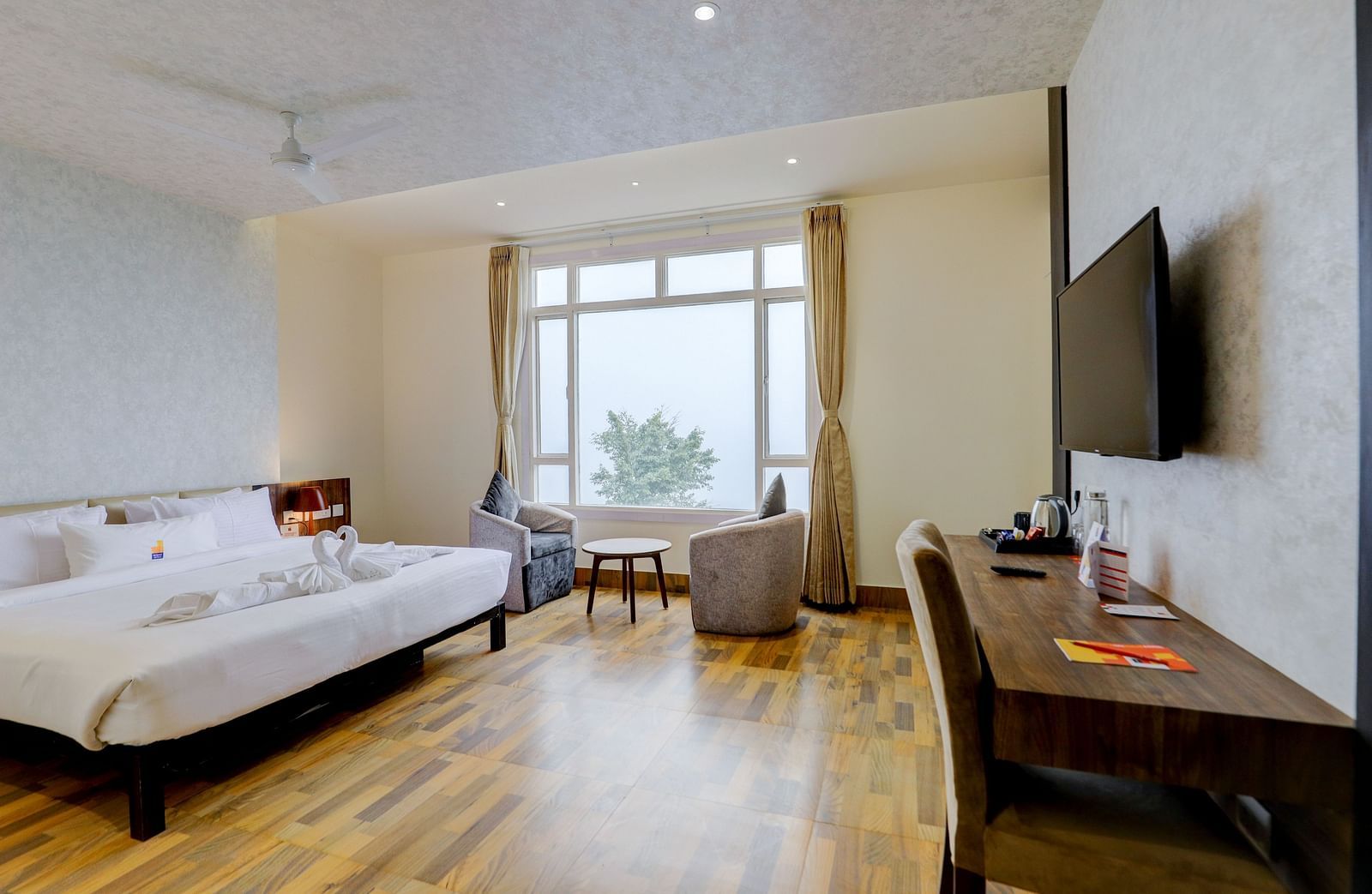 view of a TV and a  king size bed placed next to a window Suite at Banari Regency by Summit, Namchi