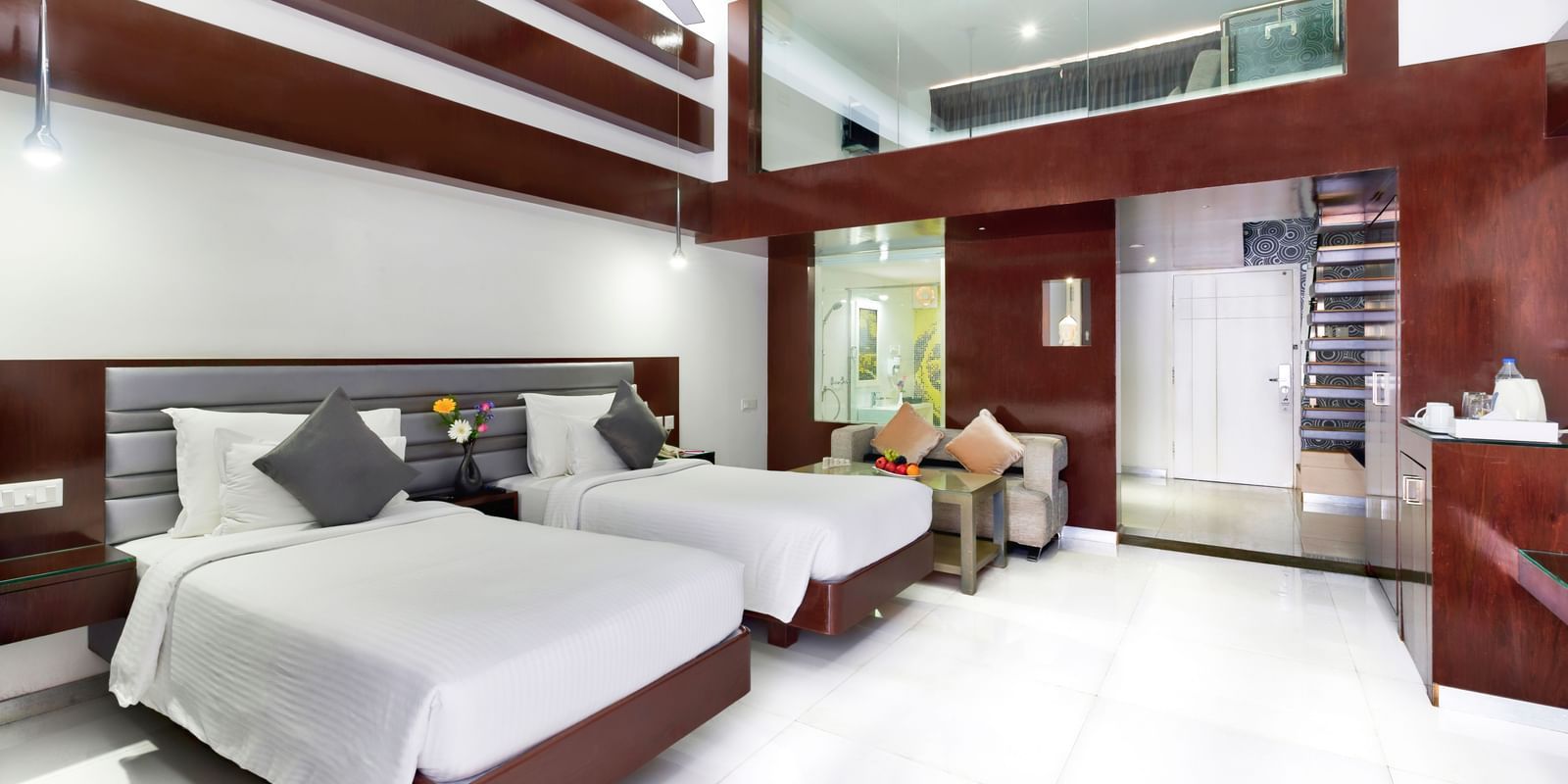 A clean hotel room featuring two beds with white linens, wooden accent walls, and a large window | Grande Duplex Twin | Grand Bay Resort and Spa