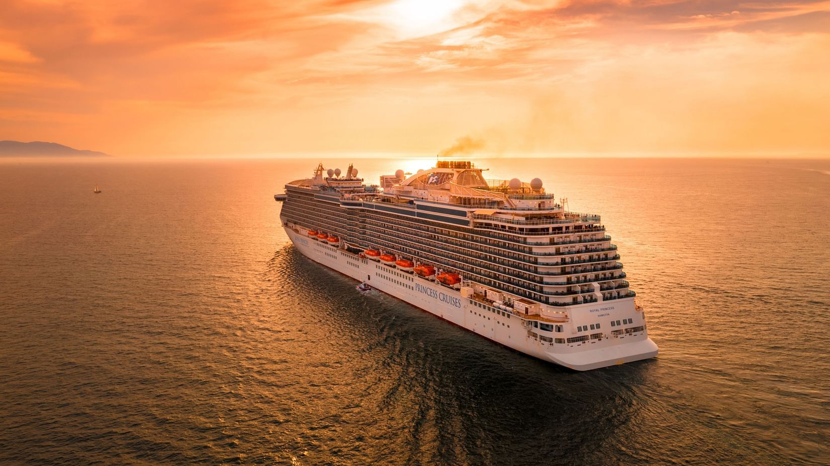 A cruise ship sailing towards the sunset