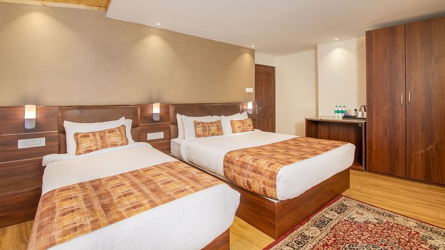 A large double bed and a single bed in the Triple Deluxe Room at Hotel Sumitel Vista T.V Tower
