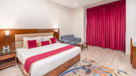 Double bed room with pink curtains at DLS Hotels On The Ganges.