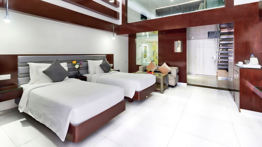 A clean hotel room featuring two beds with white linens, wooden accent walls, and a large window | Grande Duplex Twin | Grand Bay Resort and Spa