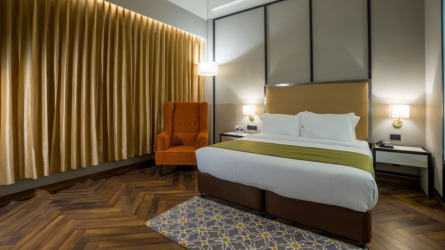 An image of a bedroom with king size bed with bedside table on each side and  sofa-Hotel Polo Towers, Agartala 