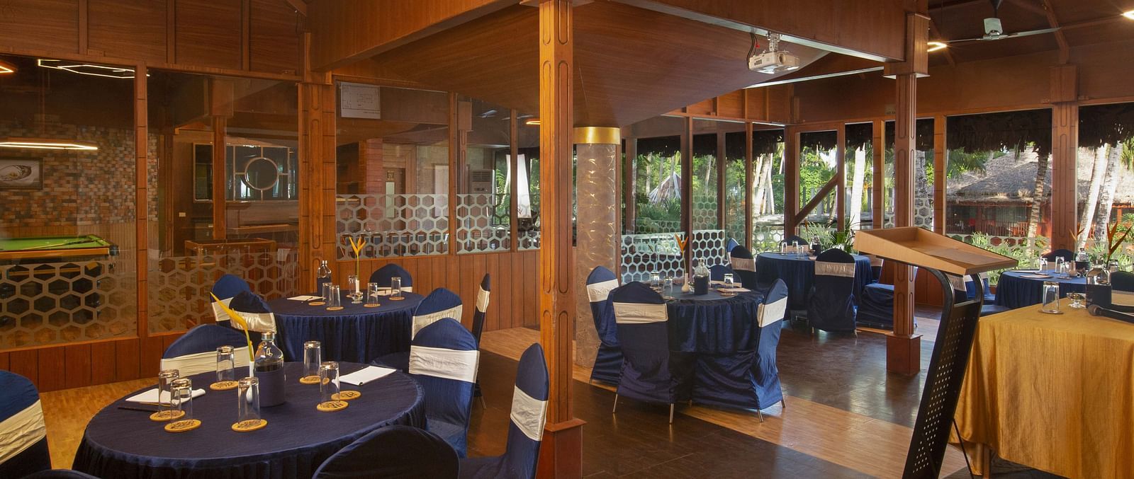A well-set dining room with dark blue tablecloths and wooden chairs. The room is well-lit with contemporary lighting, offering a sophisticated dining environment - Coral Reef Resort & Spa, Havelock