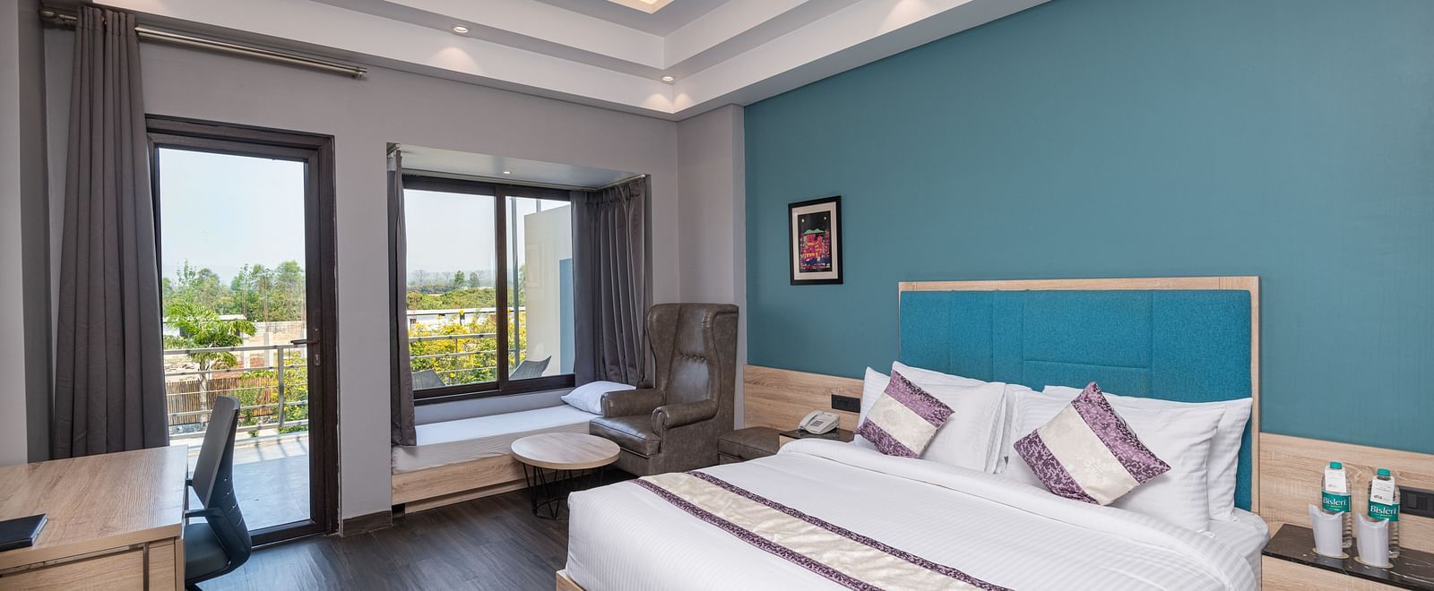 Bedroom with modern furnishings and access to a scenic balcony - DLS Forest Vines Resort & Spa, Ramnagar (Jim Corbett)