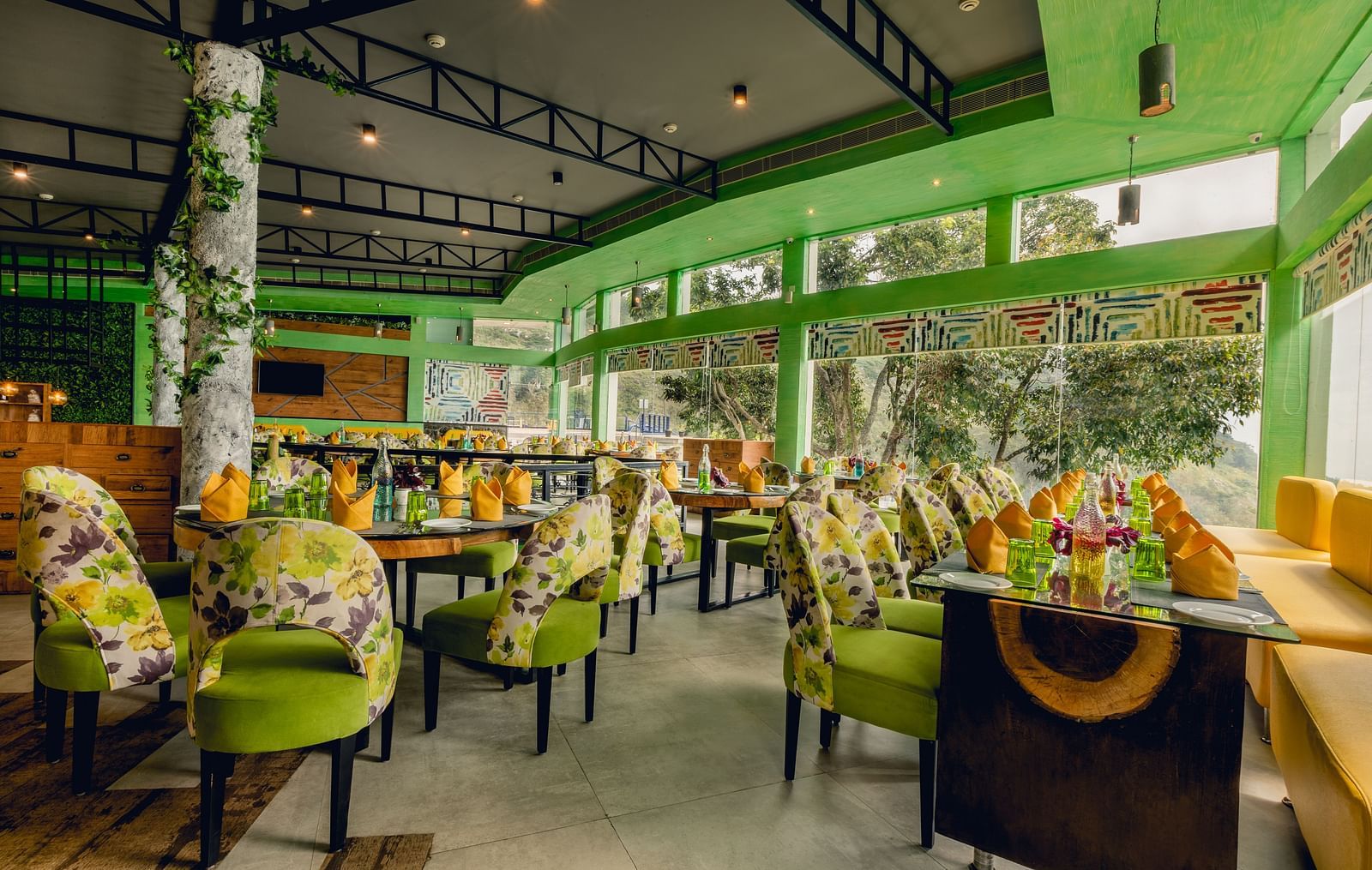 An image of a restaurant with different seating arrangement and decorative items - Great Trails Yercaud by GRT Hotels