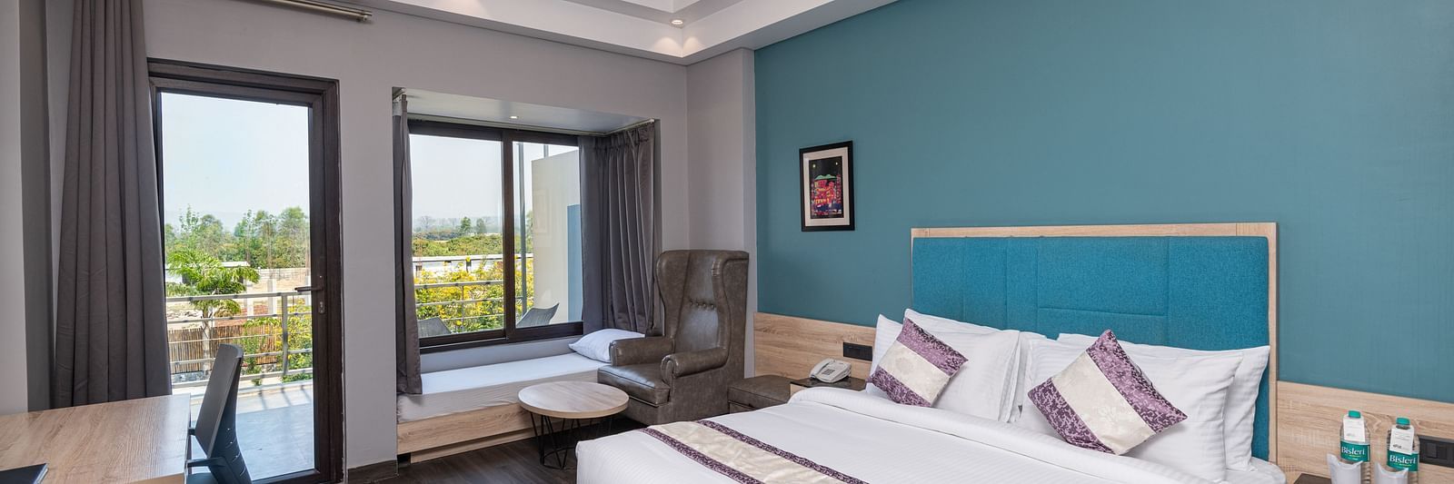 Bedroom with modern furnishings and access to a scenic balcony - DLS Forest Vines Resort & Spa, Ramnagar (Jim Corbett)