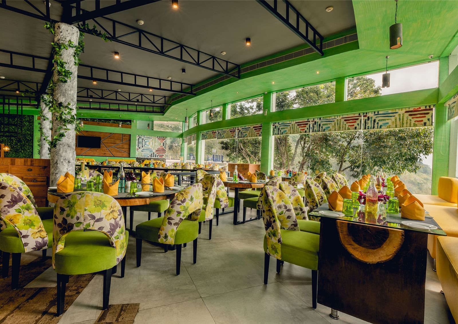 An image of a restaurant with different seating arrangement and decorative items - Great Trails Yercaud by GRT Hotels