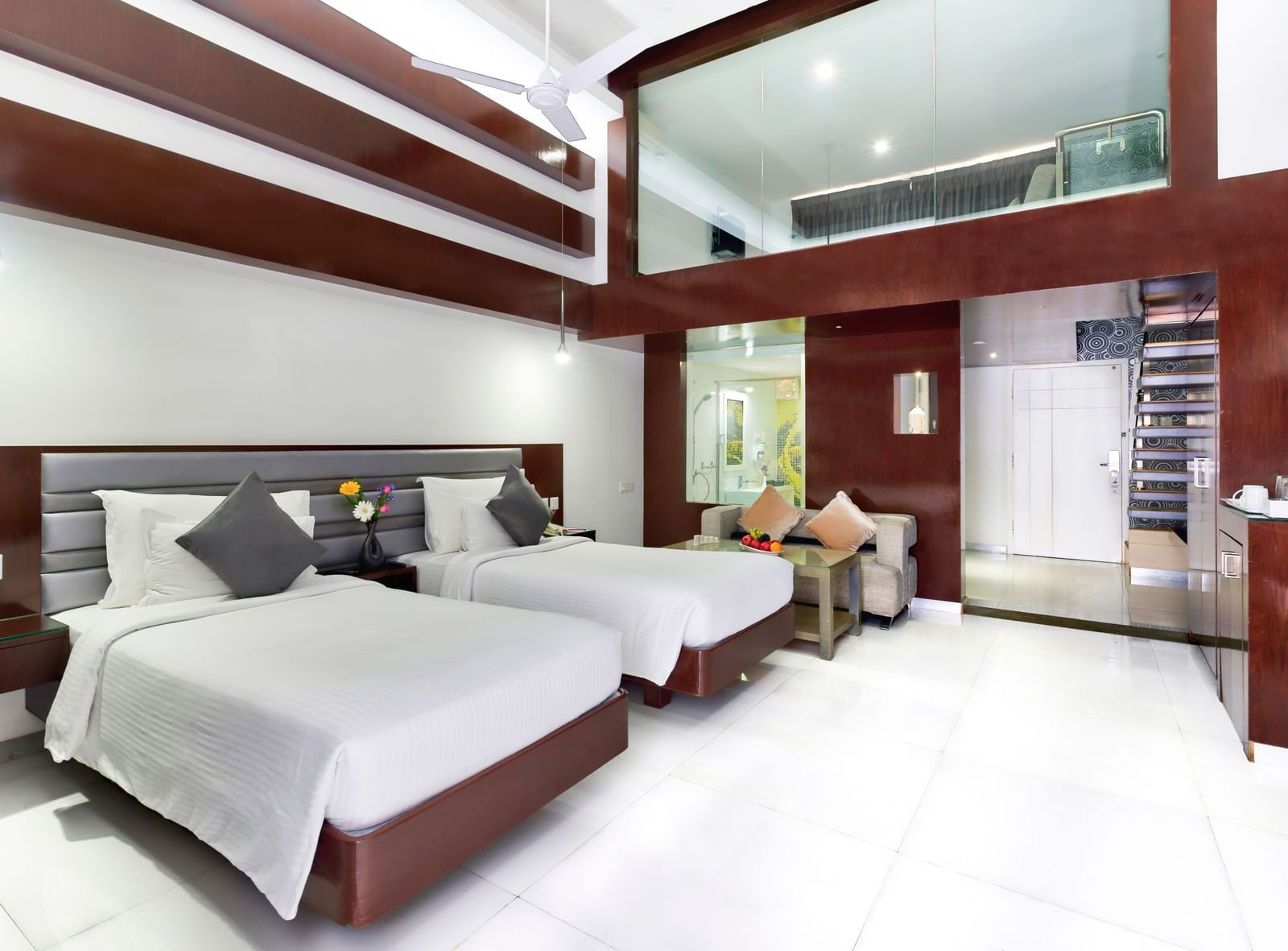 A clean hotel room featuring two beds with white linens, wooden accent walls, and a large window | Grande Duplex Twin | Grand Bay Resort and Spa