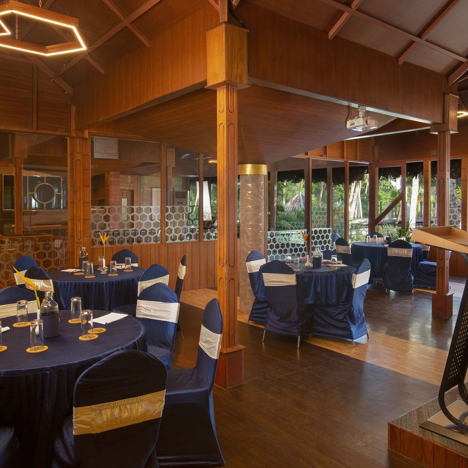 A well-set dining room with dark blue tablecloths and wooden chairs. The room is well-lit with contemporary lighting, offering a sophisticated dining environment - Coral Reef Resort & Spa, Havelock
