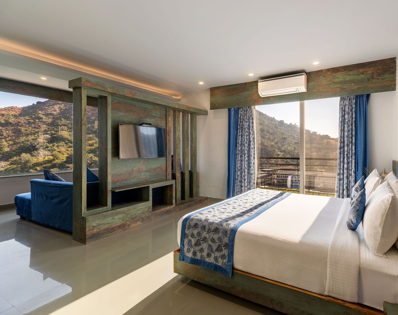 A bedroom with a made bed, patterned runner and a mountain view through the window - Via Lakhela Resort & Spa 