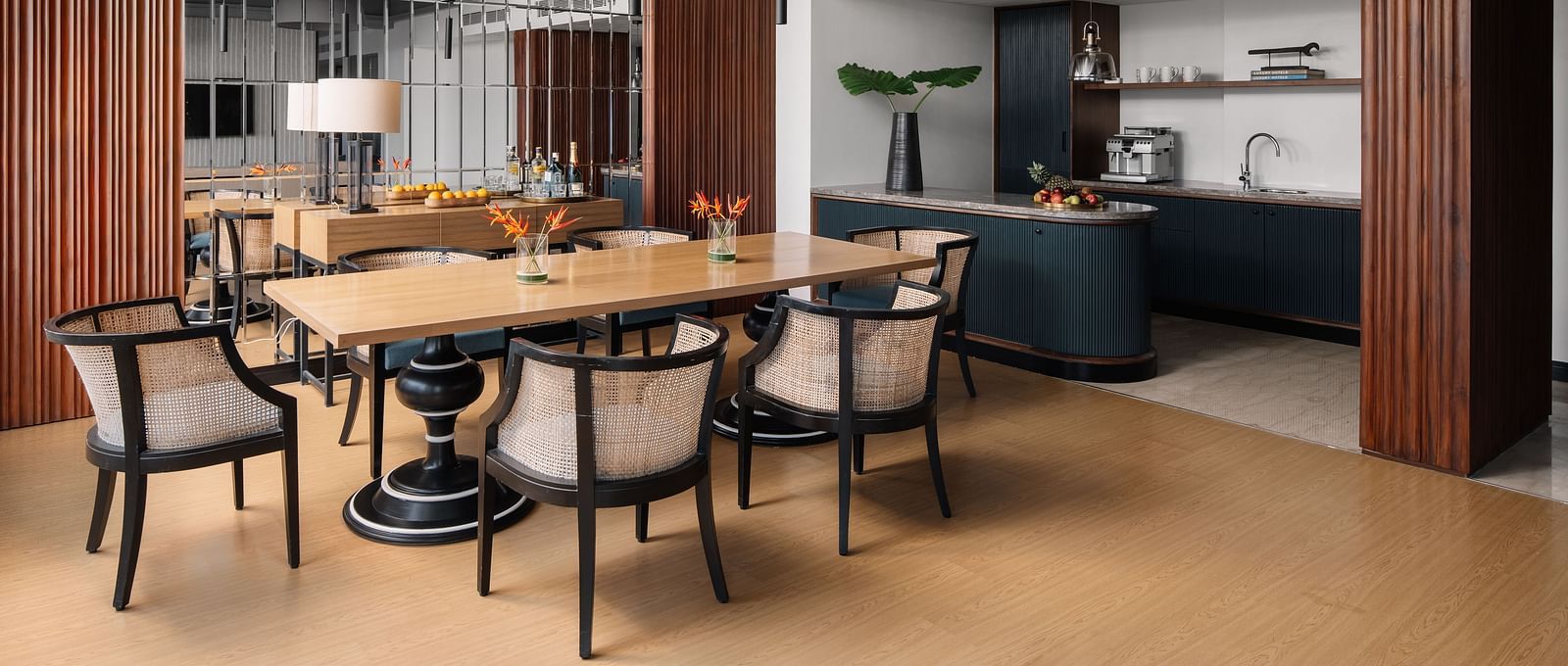 A seating area with a table and chair around it and a kitchen counter in the corner at The Raintree Hotel, St. Mary's Road.