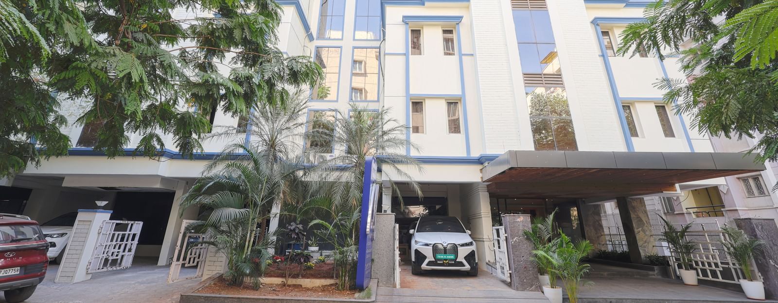 The exterior view of the Monday Hotels HITEC City, Hyderabad building surrounded by greenery.