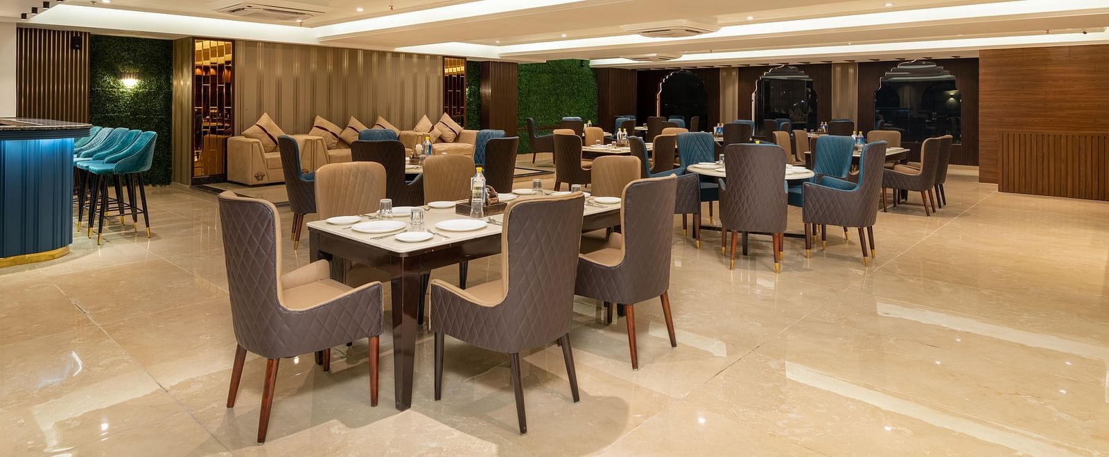 A shot of a restaurant at with chairs and tables and warm lighting - DLS Grand Luxotica, Dehradun