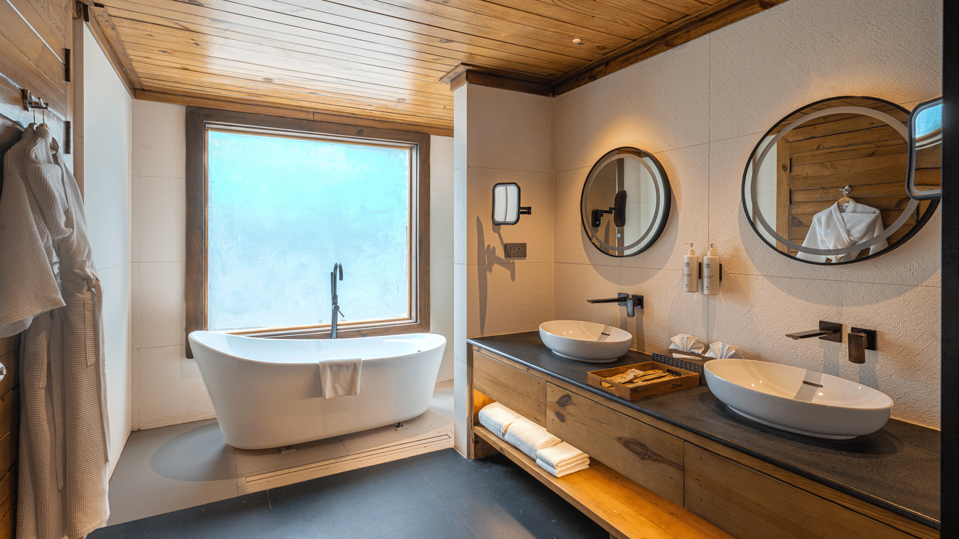 Premium Wooden Cottage with Bathtub bathroom featuring a freestanding tub and dual sinks at The Ananta Udaipur.