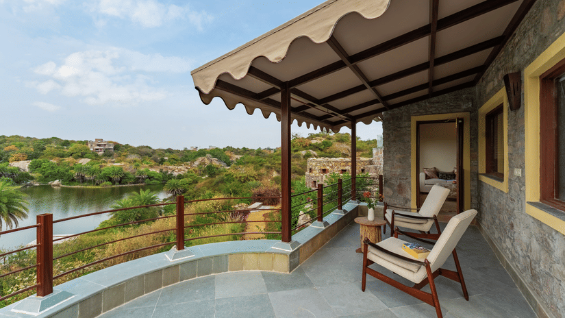 Two chairs and a small table in between them on a balcony inside a room - Chunda Shikar Oudi, Udaipur.