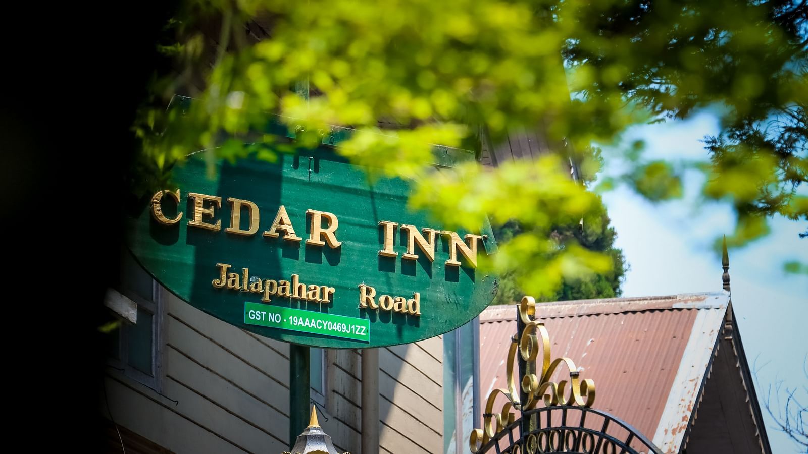 Cedar Inn nameboard on a gate with trees in the background