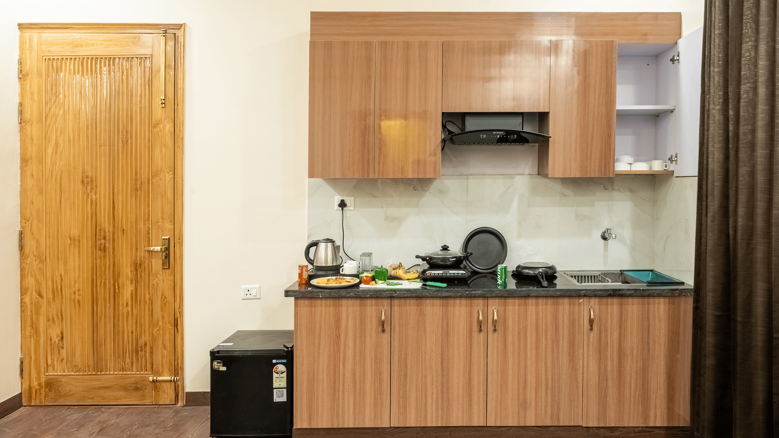 Hotel suite featuring a kitchenette with cabinets, countertop, and modern appliances.
