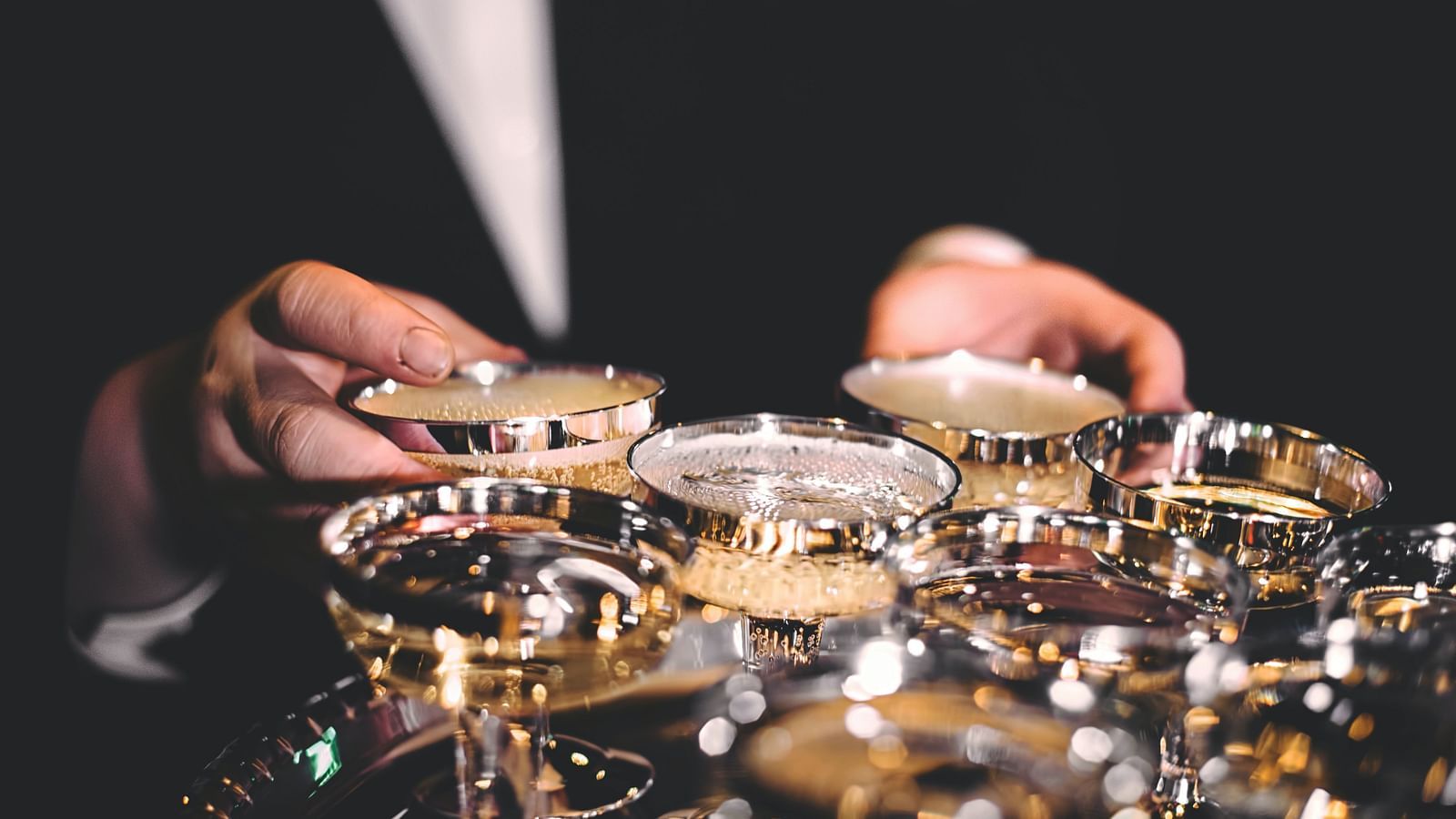 a waiter holding a tray with champagne in glasses 