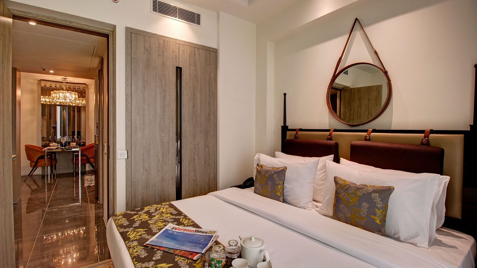 A kind bed with many pillows and a bed runner on it inside Deluxe Suite at Rhythm Gurgaon