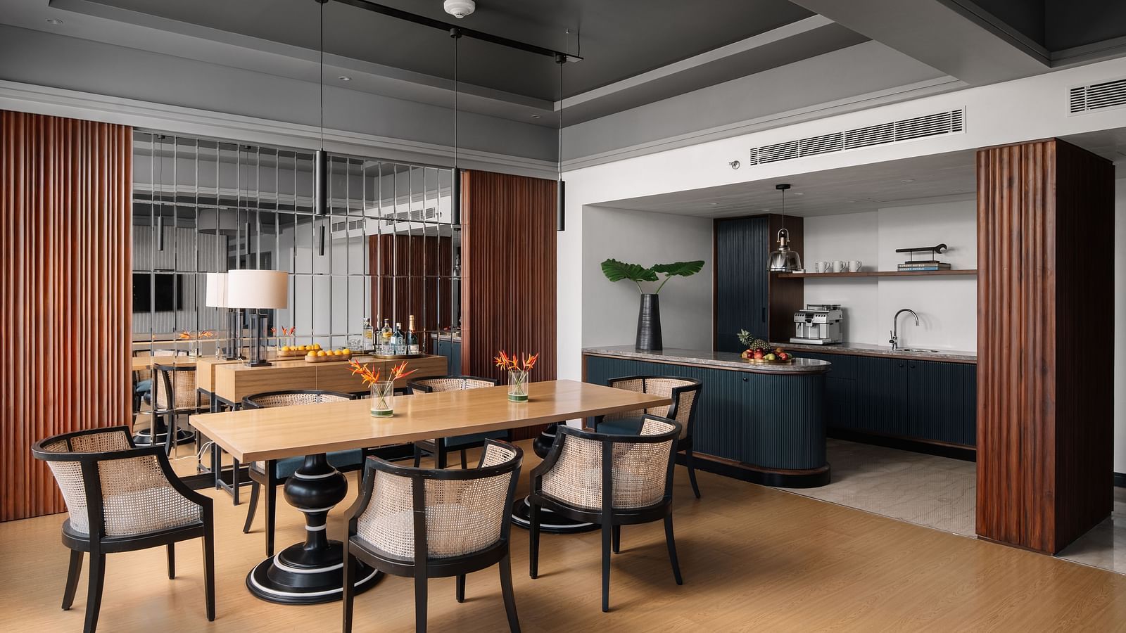 A seating area with a table and chair around it and a kitchen counter in the corner at The Raintree Hotel, St. Mary's Road.