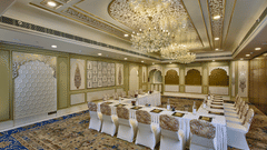 Elegant meeting room with a U-shaped table, ornate ceiling, chandeliers, and patterned carpet - Heritage Village Resorts & Spa.