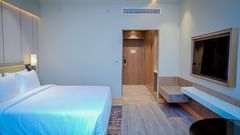 A hotel room in Hargeisa near airport featuring a double bed and a wall-mounted television - Serene Sarovar Premiere Hargeisa