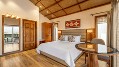A king bed with study table on the side inside Executive cottage 1 at Shyama Sarovar Portico Orai