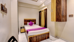 Classic Single Room with bed, purple accent pillow, AC unit and overhead wooden wardrobe at VITS Select Kharadi Pune