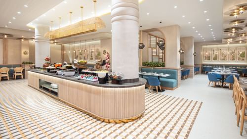 A buffet table with a variety of dishes and a modern chandelier.