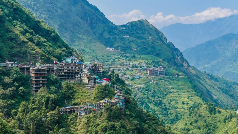A town situated on the slopes on a mountain covered with lush greenery