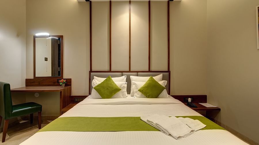 Front view of a double bed with side tables next to it inside Classic AC Room - Fortune House, Magarpatta