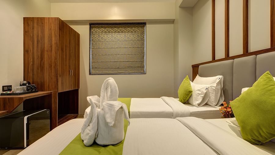 A close up shot of dove towels on the twin beds inside Premium Twin Sharing Room - Fortune House, Magarpatta
