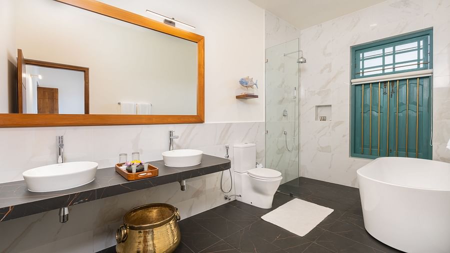 A modern bathroom featuring a double vanity with wooden accents, a freestanding bathtub, and large windows for natural light - Deluxe Room at Heavensa Villas and Suites by the Clarks, Galle