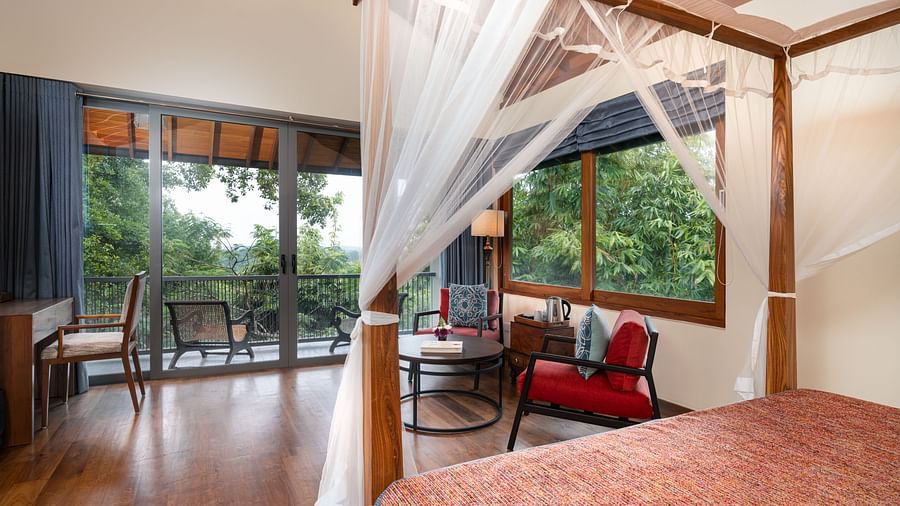  A spacious bedroom with a canopy bed and a seating area, opening to a private terrace with garden views - Executive Suite at Heavensa Villas and Suites by the Clarks, Galle