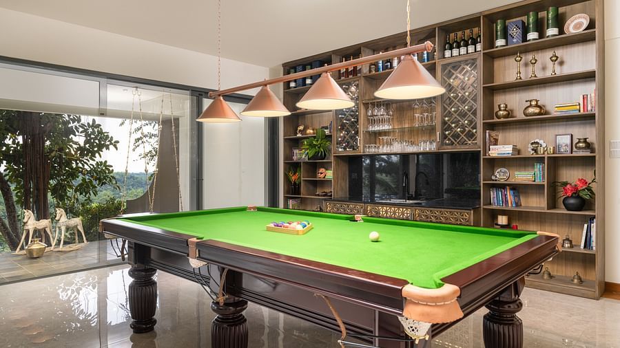 A pool table in a well-lit recreational room with shelves filled with books and decorative items, alongside large windows providing natural light - Heavensa Villas and Suites by the Clarks, Galle