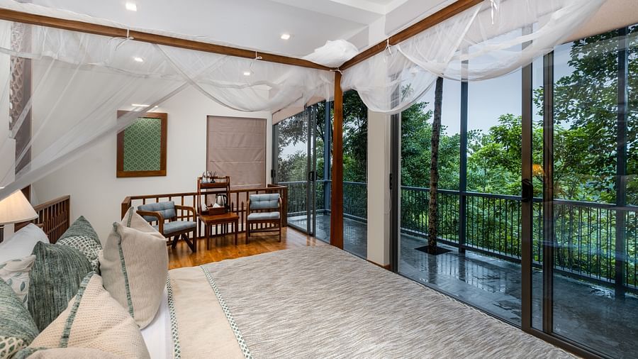 A serene room with twin canopy beds, large glass doors, and a view of the lush greenery outside - Family Suite Garden View at Heavensa Villas and Suites by the Clarks, Galle