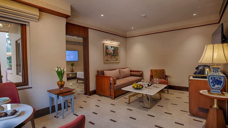 Spacious living room with a sofa, coffee table, large window with outdoor views, and elegant lighting, creating a warm and inviting atmosphere