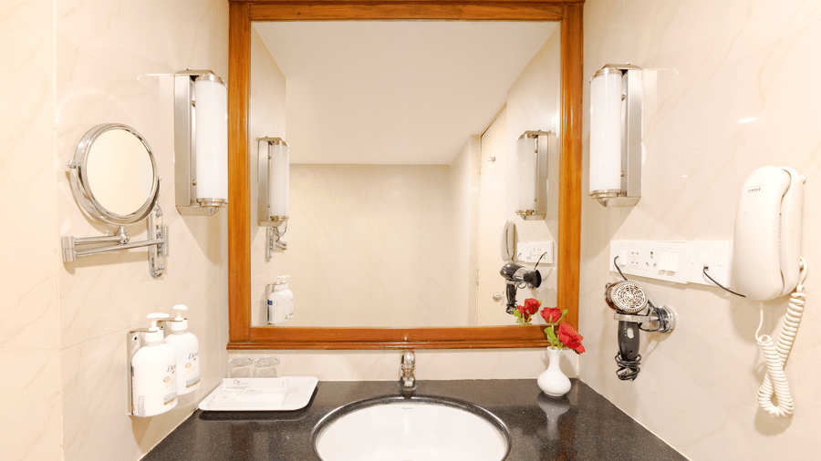 MGM Mark Whitefield |  A bathroom with a toilet seat, a mirror, and toileteries.