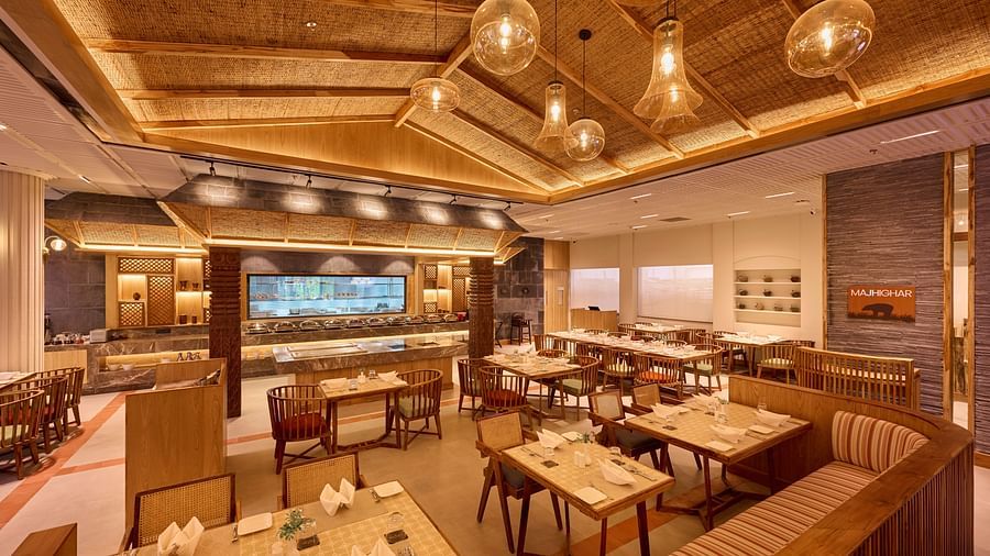 Spacious indoor dining area with elegant wooden ceiling and pendant lights - Royal Tulip, Chitwan