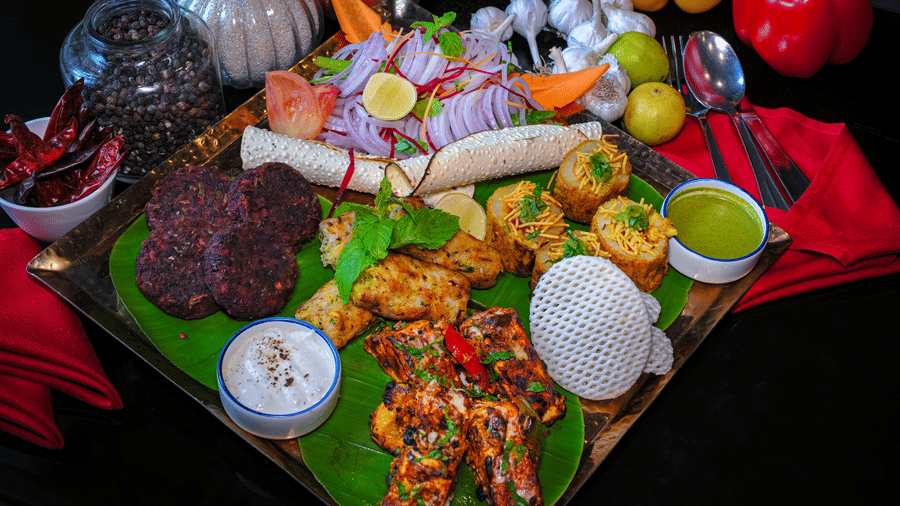 A special dish served on a plate with capsicums and spice bottles placed in the backdrop for decoration at Clarks Hotels.