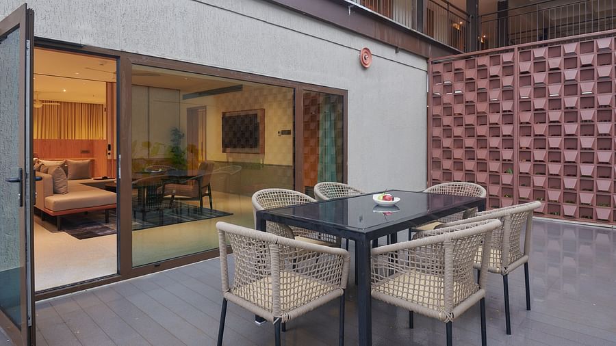 Terrace with a table and chairs surrounding it, a glass door leading to the bedroom at The Dukes Retreat.