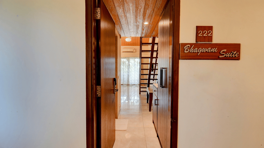 Entrance to duplex suite with room signage and wooden staircase at VITS Lonavala.