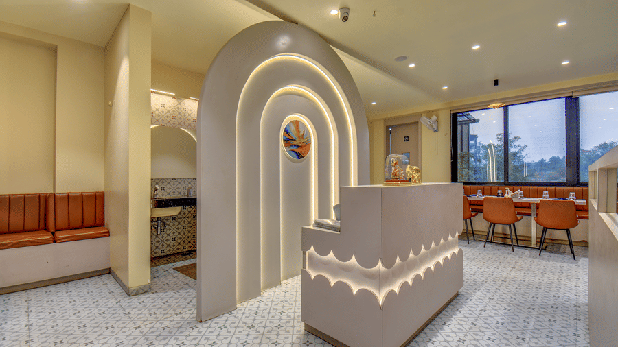 Hotel restaurant with an arched feature wall, soft lighting, and neatly arranged dining tables at VITS Select Nashik Hotels & Resorts.