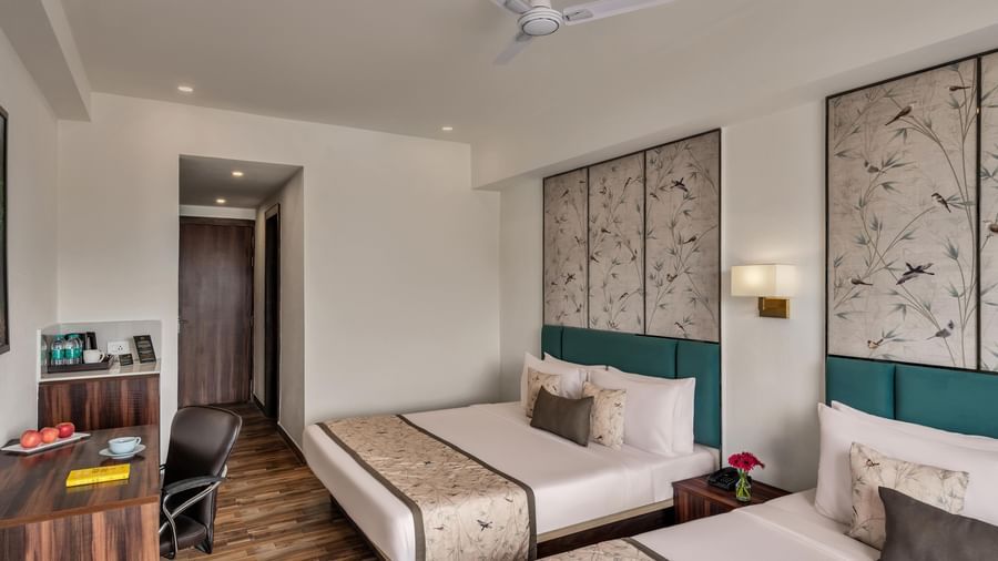 Guest room at Voyage Milestone Hotel and Banquet with twin beds and wooden flooring.