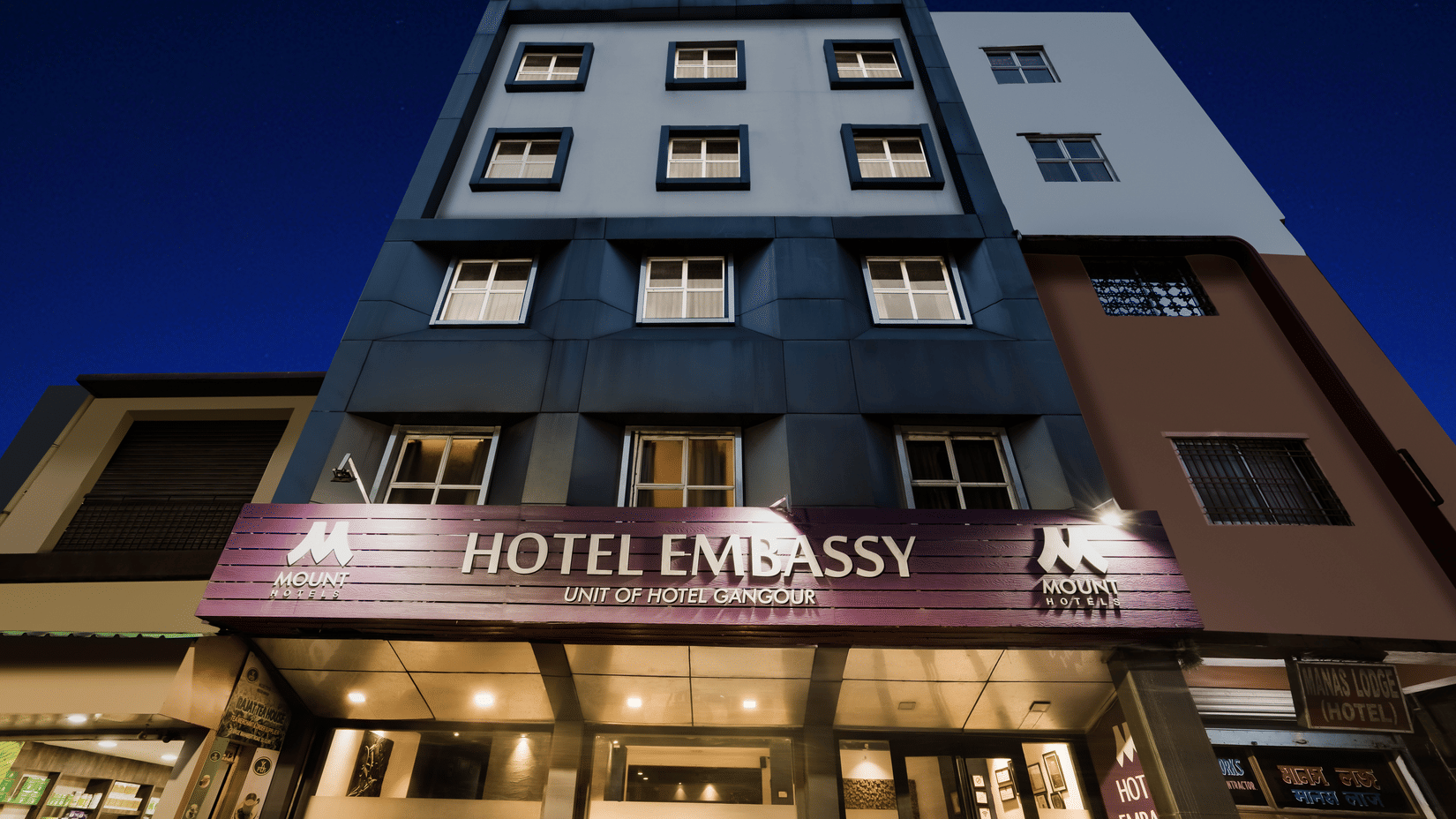 Mount Embassy Hotel in Siliguri with illuminated signage and structured facade.