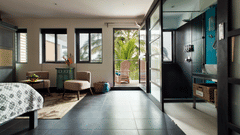 A brightly lit room at Owl and the Pussycat Hotel In Galle with a sitting area and windows overlooking greenery.