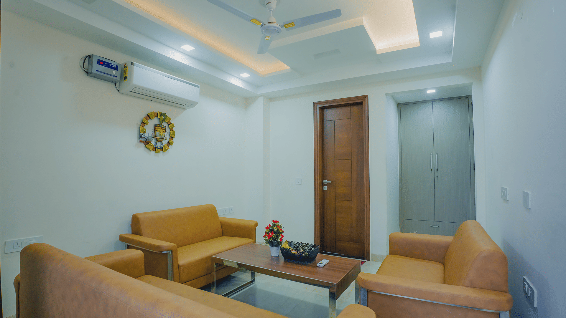 Lounge area of Lime Tree Hotels & Service Apartment Private Limited featuring orange armchairs and a view towards the corridor.