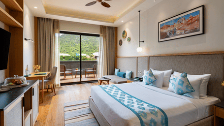 An overview of the Elegant Room with a ceiling fan and a painting above the bed at Pushkara Resort & Spa, Ajmer, the Best Place to Stay in Pushkar.